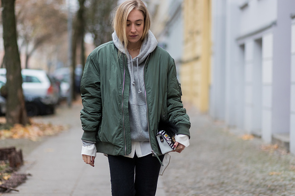 BERLIN, GERMANY - NOVEMBER 26: Sonia Lyson (@soniafrancex / PR Manager) wearing black cropped denim jeans Zara, grey hoody weekday white blouse weekday, khaki bomber jacket weekday, white Furla bag, black net tights falke on November 26, 2016 in Berlin, Germany. (Photo by Christian Vierig/Getty Images)